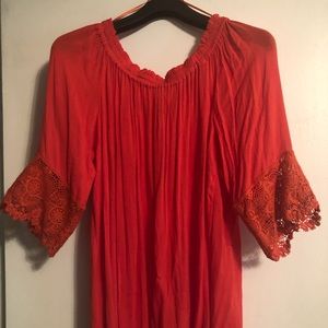 A orange top with lace accents on the sleeves.